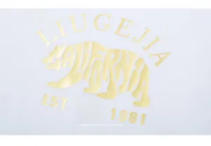 Detail of gold foil polar bear silhouette and CALIFORNIA lettering on white cotton tee
