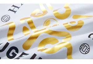Macro detail of high-quality gold foil and black letter printing on white cotton T-shirt