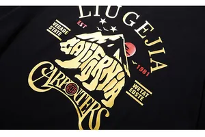 Detail of vintage gold polar bear print on black oversized cotton street style T-shirt