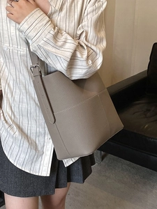 Chic grey pebbled leather bucket bag with adjustable shoulder strap for daily casual style