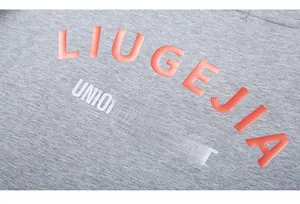 Close-up of 3D puff print lettering LIUGEJIA on grey cotton knit t-shirt fabric detail