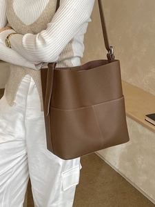 Dark brown bucket bag in lychee texture leather with contrast white stitching detail