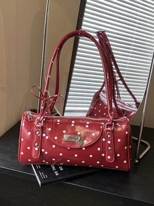Chic red polka dot cylinder handbag with heart charm and bow detail in a vintage style
