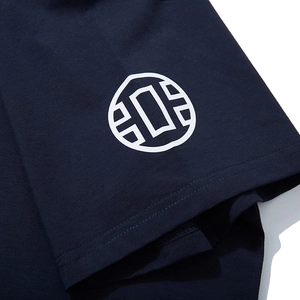 Close-up of navy blue cotton T-shirt sleeve with white circular graphic logo print