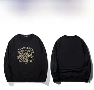 Detail of golden leopard head print and lettering on a black streetwear sweatshirt