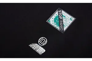 Detail of black cotton hoodie featuring stitched fabric label and high-quality screen printing