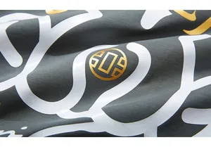 Macro shot of dark grey T-shirt fabric with premium white and metallic gold graphic print