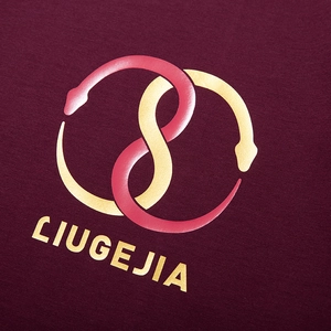 Close-up of golden interlocking snake print on a burgundy oversized fashion cotton t-shirt