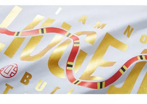 Close-up of premium gold foil printing and red snake graphic on white cotton fabric