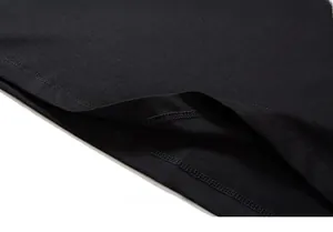 Detail of double-needle stitching on the hem of a black oversized cotton knit t-shirt