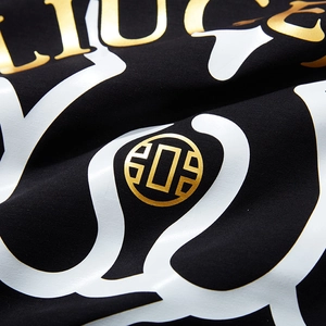 Oversized black cotton T-shirt featuring a gold metallic bear emblem and artistic print