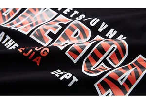 Détail de l'imprimé graphique tigre sur un t-shirt en coton noir à texture épaisse