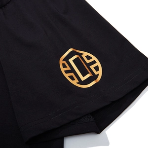 Men's oversized black t-shirt featuring metallic gold geometric logo and premium cotton texture
