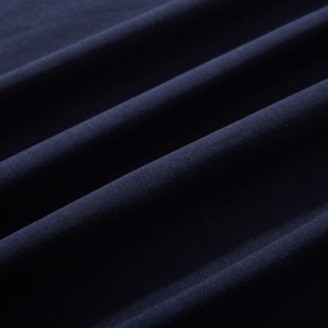 Close-up of premium navy blue cotton fabric texture on a loose oversized fashion T-shirt