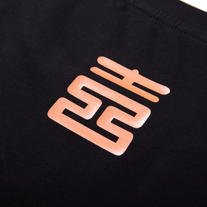 Close-up of black cotton T-shirt featuring a high-gloss orange reflective lion logo print