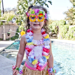 Hawaiian beach party outfit with grass skirt and pineapple glasses by a pool