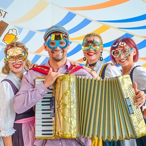 Colorful Oktoberfest party paper glasses with beer and accordion props for celebration