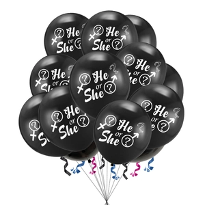 Close-up of black latex gender reveal balloons with white He or She text and ribbons