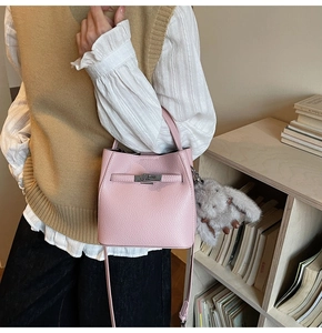 Detailed close-up of pink lychee grain leather bucket bag with silver metal swivel lock