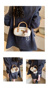 Detail view of retro white bowling bag with brown handle and cute plush bear charm