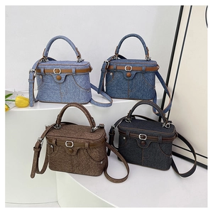 Detail of four denim crossbody bags on steps with vintage metal buckles and leather trim