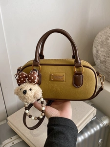 Vintage mustard yellow bowling bag with pebble leather texture and cute dog charm pendant