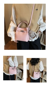 Detailed shot of pink bucket bag with silver buckle and plush bunny charm on a bookshelf