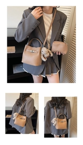 Brown lychee grain bucket bag with matching pouch and plush bunny charm on a model