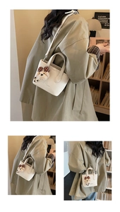 Detail of white bucket bag with pebble leather texture and a cute teddy bear charm
