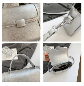Detail view of silver metallic handbag showing brushed texture, square lock, and inner pocket