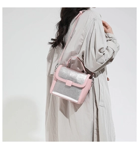 Detail of pink and silver square crossbody bag with glitter finish on female model