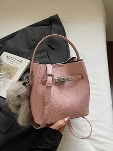 Pink lychee grain leather bucket bag with silver lock, shoulder strap and bunny charm
