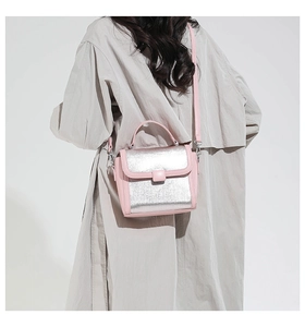 Detailed back view of a pink and silver patchwork square crossbody bag worn by a model