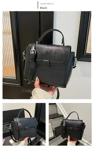 Detail of black structured handbag with glossy cracked texture and adjustable strap