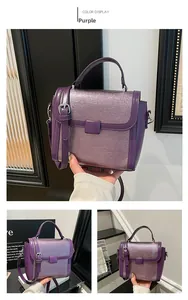 Close-up of purple matte leather handbag featuring brushed texture and silver hardware