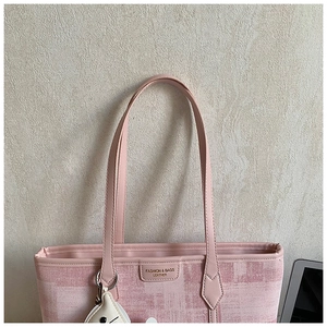 Detail of pink plaid tote bag with leather tag and cute white plush charm accessory