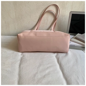 Close-up of pink tote bag showing lychee grain leather texture and durable stitching