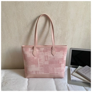 Detail of pink floral canvas tote with premium leather handles and geometric patterns