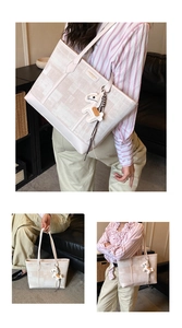 Detail of off-white tote bag with canvas texture, leather trim, and horse pendant