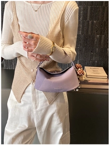 Detail of light purple leather shoulder bag with polka dot bow and pearl charm