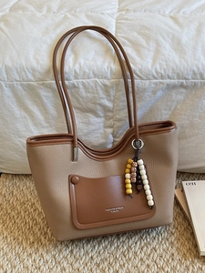 Fashionable khaki leather tote bag with brown front pocket and elegant beaded tassel