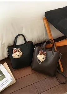 Détails de sacs fourre-tout minimalistes en noir et marron avec pendentifs ours