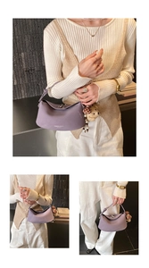 Detailed view of purple matte leather croissant bag with cute bear and mushroom charms