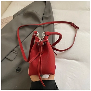 Detail of red pebbled leather bucket bag with silver hardware and drawstring closure