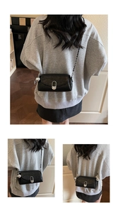 Vue détaillée d'un sac à bandoulière noir avec chaîne argentée et pendentif sphérique