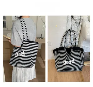 Detail of black and white striped tote bag with good letter logo and large capacity