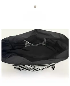 Internal view of striped canvas tote bag showing black lining and open inner pocket
