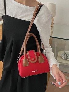 Fashionable red canvas crossbody bag with brown leather trim and silver logo detail
