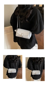 Détail du sac bandoulière argenté avec chaîne métallique et breloque ronde en métal