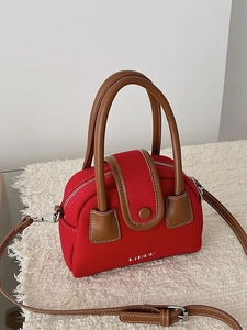 Red canvas and brown leather crossbody bag with LIVUU logo on cozy white backdrop